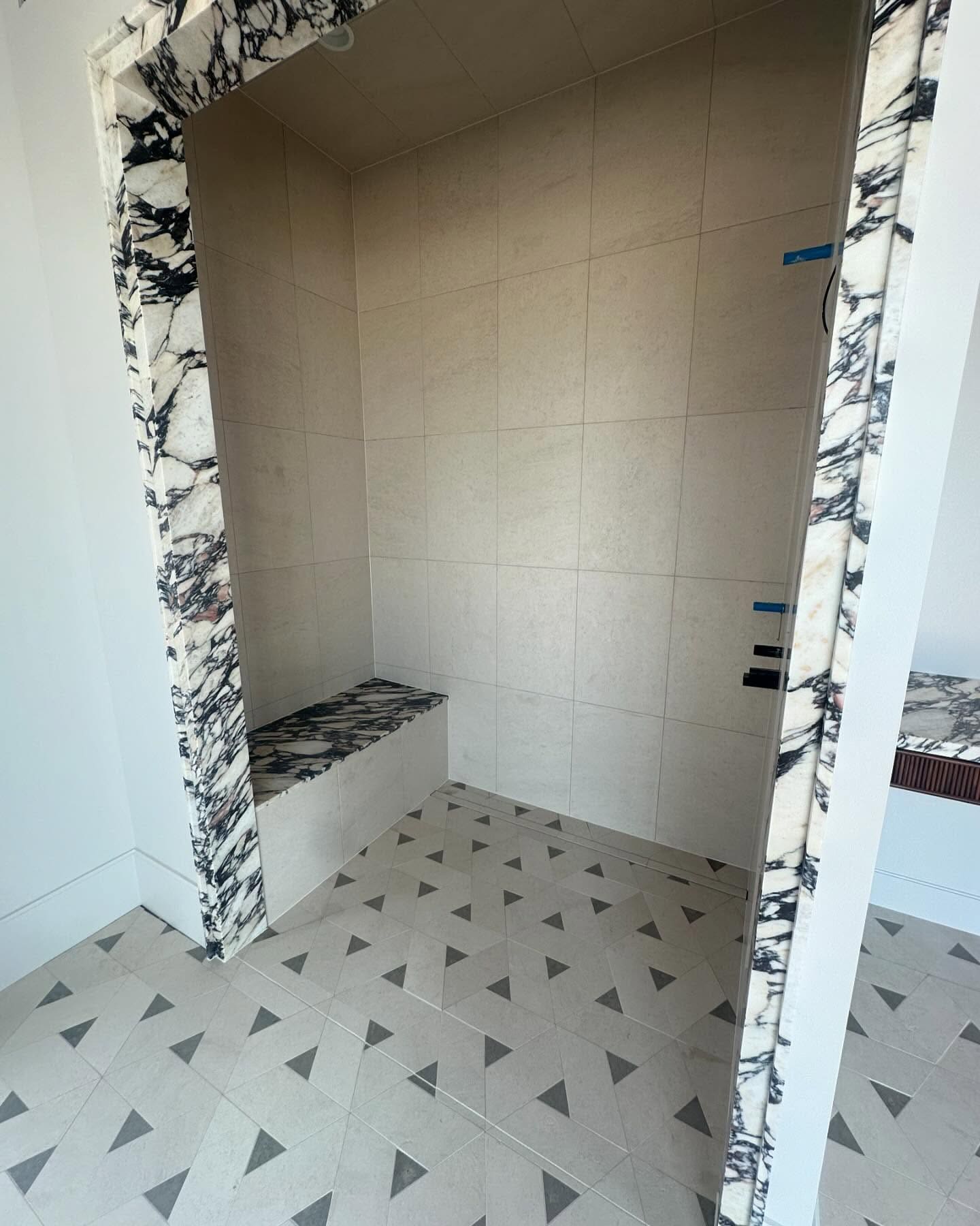 Custom shower framed in Calacatta Viola marble
